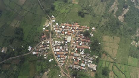 zoom out drone shot of small town in hills | clouds passing bird's eye view | 4k