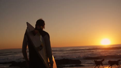 Hombre-Caminando-Con-Tabla-De-Surf-En-La-Playa-4k