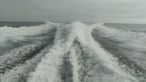 Estela-De-Agua-Vista-Desde-Atrás-De-Un-Bote-De-Motor-En-Movimiento-Rápido-En-Un-Día-De-Cielo-Despejado,-Mar-Azul,-Superficie-De-Agua