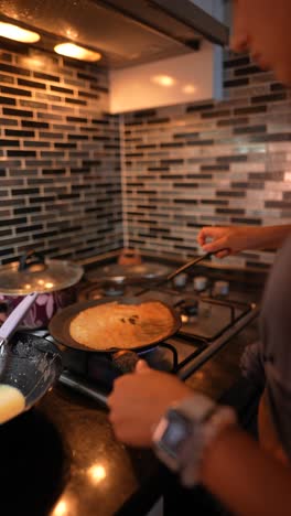 woman cooking pancakes in kitchen