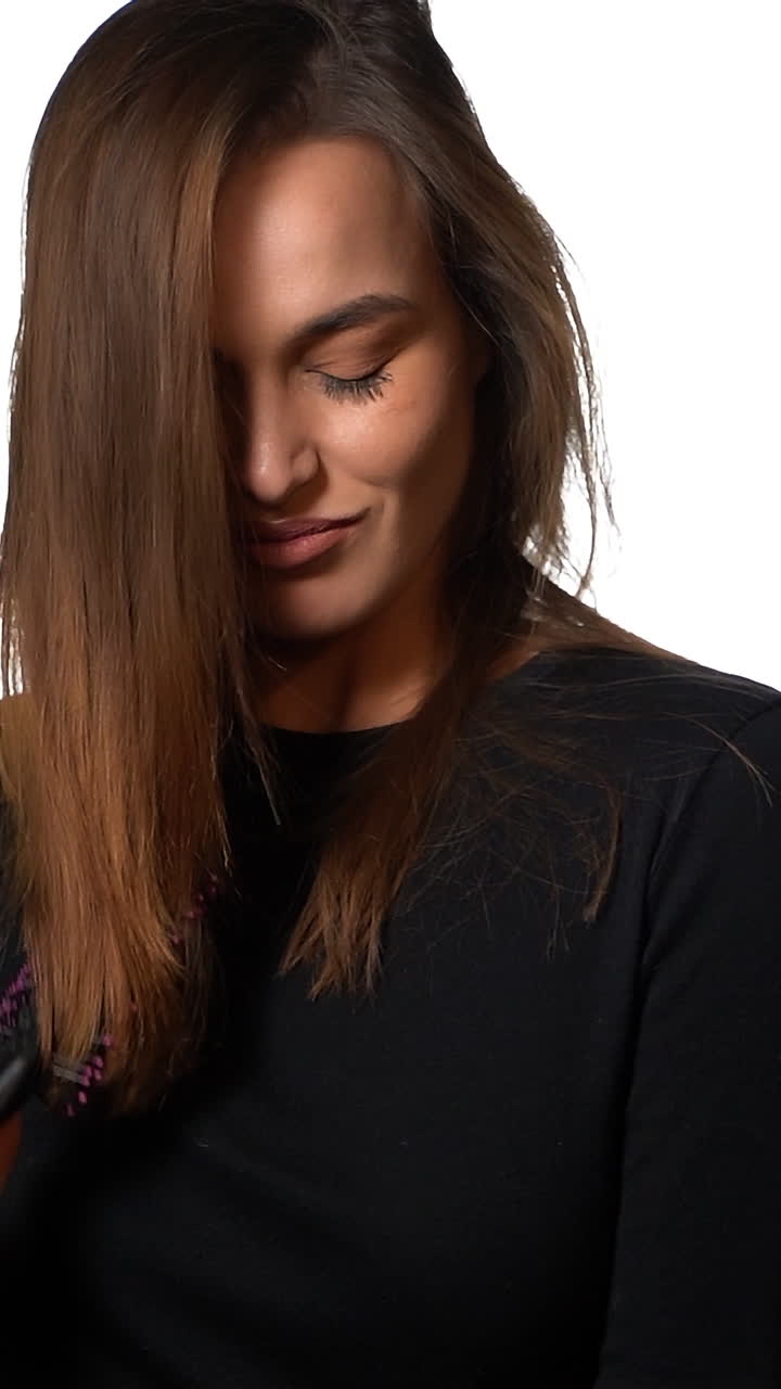 Pathos woman brushing her hair. Pretty beautiful charming woman with pathos view brushing hair, isolated on white background. Vertical video