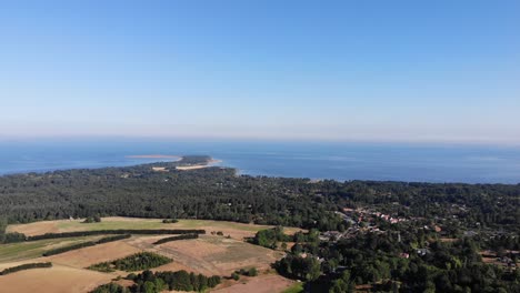 Aerial-view-of-the-coastline-of-Sejerøbugten-with-hills,-fields-and-ocean