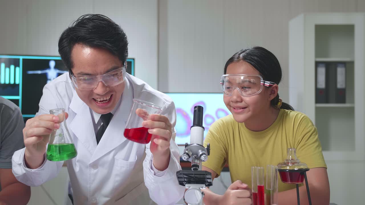 Young Asian Boy And Girl Learning Science Experiment In Laboratory With Teacher In Classroom. Study With Scientific Equipment And Test Tubes