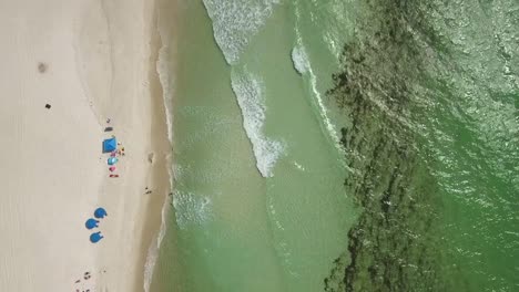 Aerial-drone-of-green-waves-and-beachgoers-on-Panama-City-Beach,-Florida