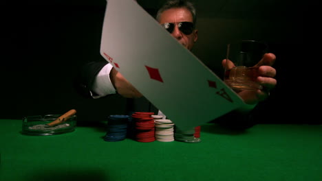 cool gambler throwing cards to camera