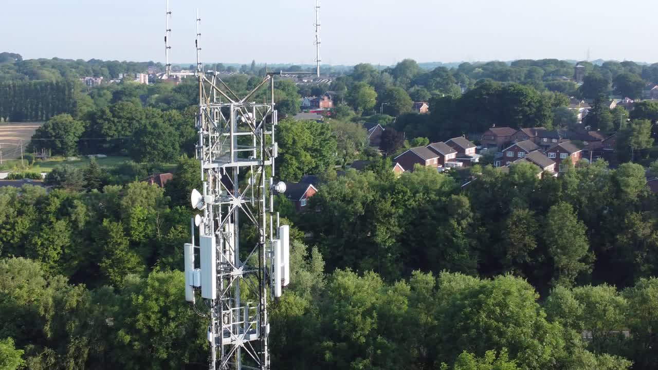 antena de torre de radiodifusión 5g en el campo británico con vehículos en segundo plano vista aérea ascendente derecha