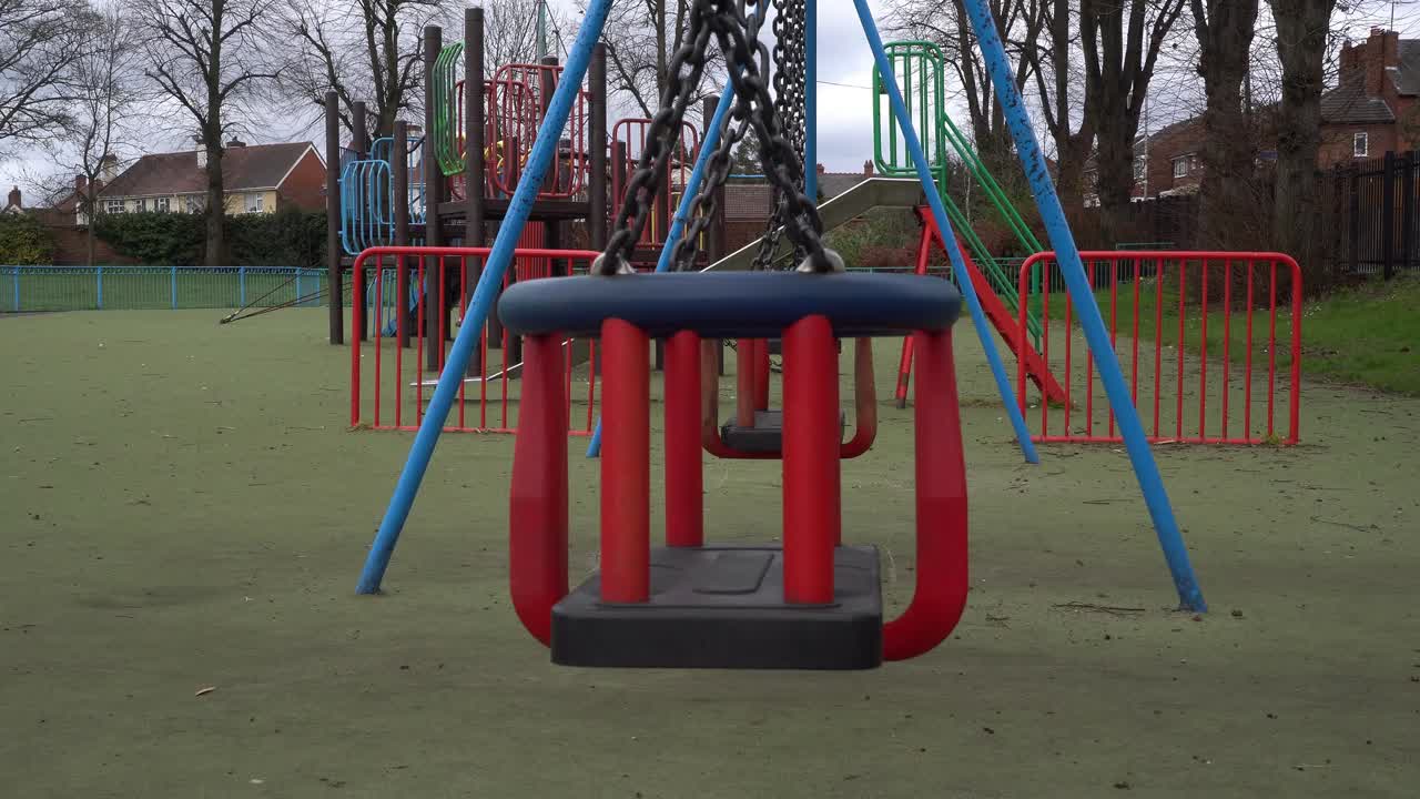 Childrens swing in deserted public playground during Coronavirus Pandemic