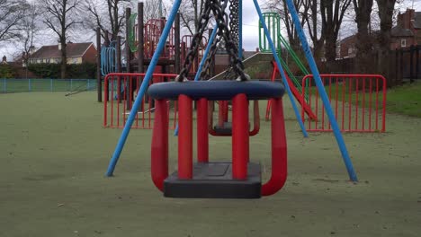 childrens swing in deserted public playground during coronavirus pandemic