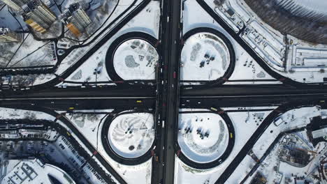 Drone-view-freeway-overpass-in-city.-Car-traffic-on-snowy-highway-junction
