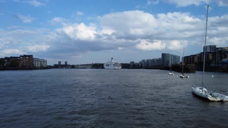 Drone-shot-flying-low-over-River-Thames-with-boat-and-ship-in-London