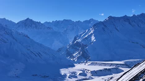 snowy mountain valley under a clear blue sky