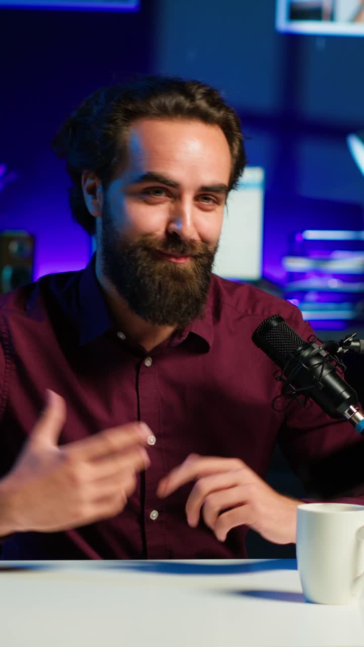 Video verticale: content creator allegro che conduce uno show online in uno studio illuminato con luci RGB