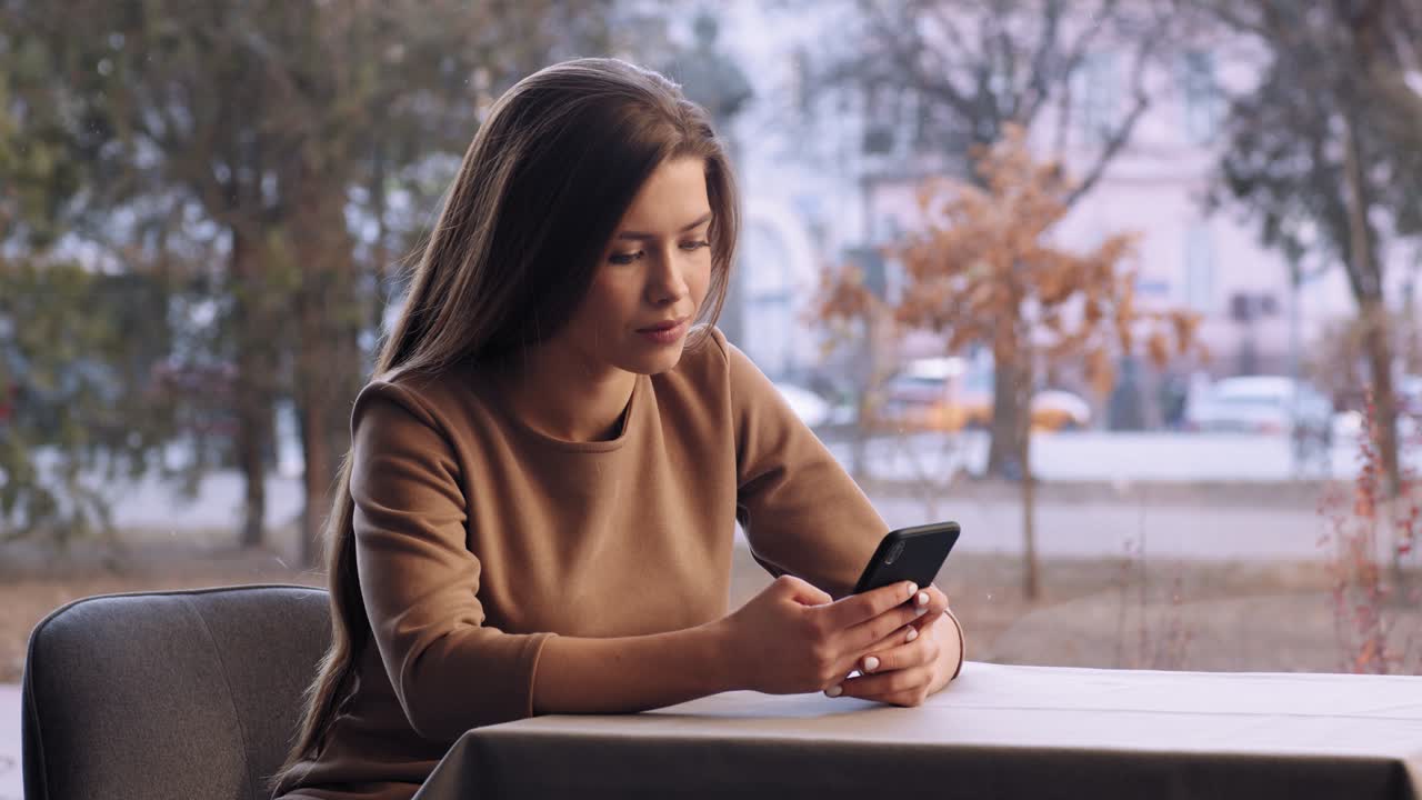 mujer usando teléfono en café