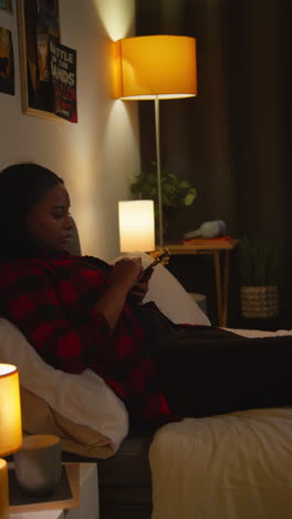 mujer usando teléfono inteligente en la cama por la noche