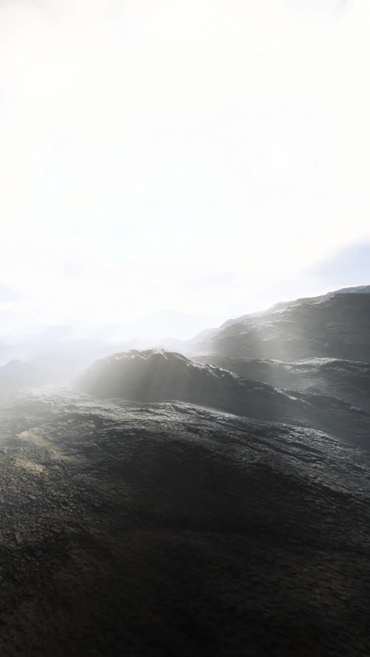 Mountains under bright sky with fog covering the rocky landscape during the day