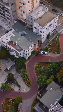 descending through the thick fog over the beautiful city. aerial footage over lombard street in san francisco, california, usa. vertical video