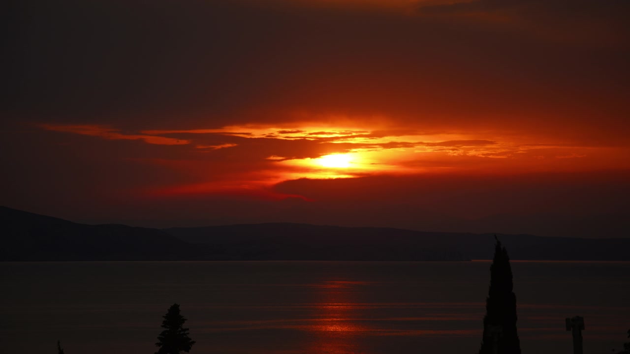 Dramatic red sunset over the calm Adriatic sea near Senj in Croatia with glowing water reflections.