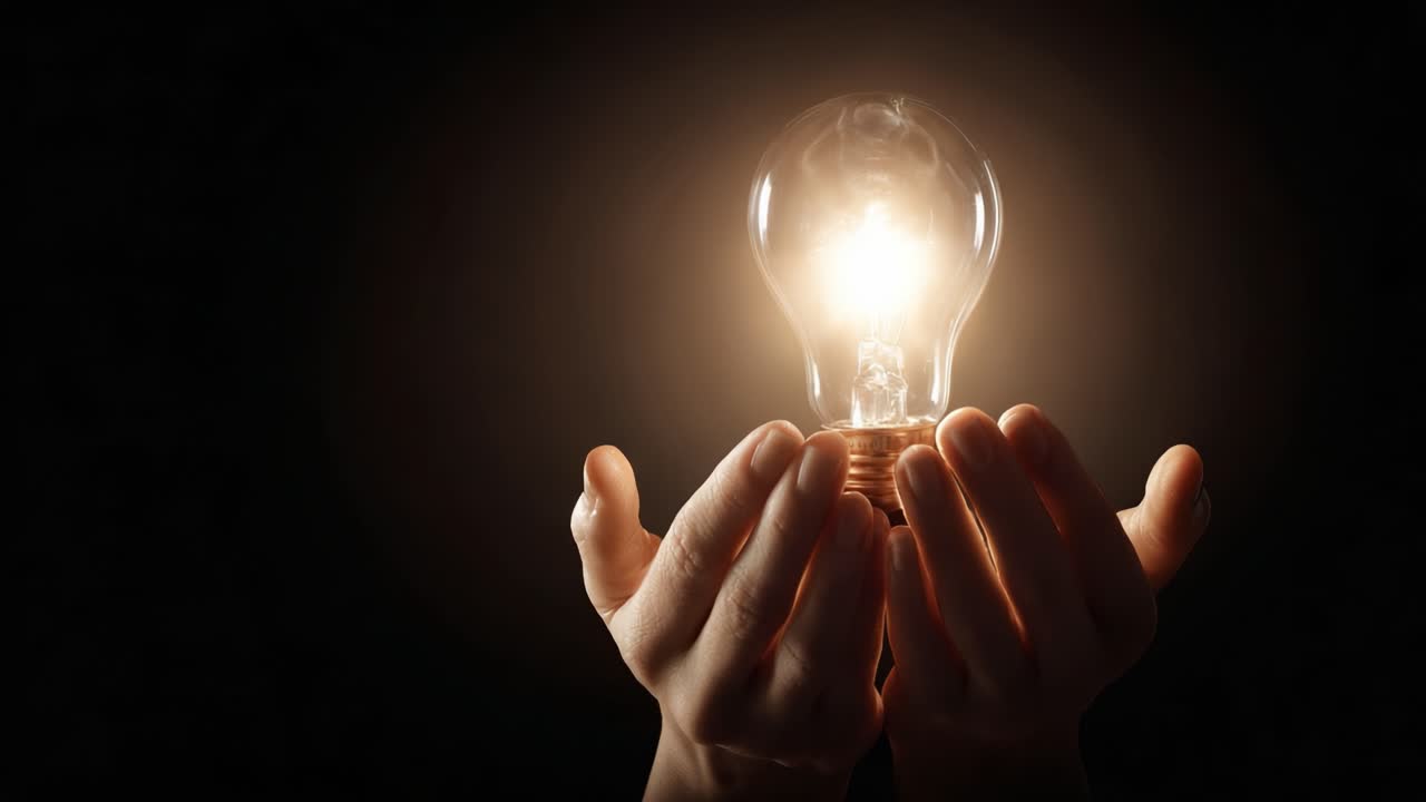 A Pair of Hands Gently Cradle a Glowing Light Bulb, Symbolizing Ideas, Innovation, and the Power of Illumination Against a Dark Background