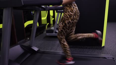 slow motion shot of a beautiful young woman training her legs on a treadmill
