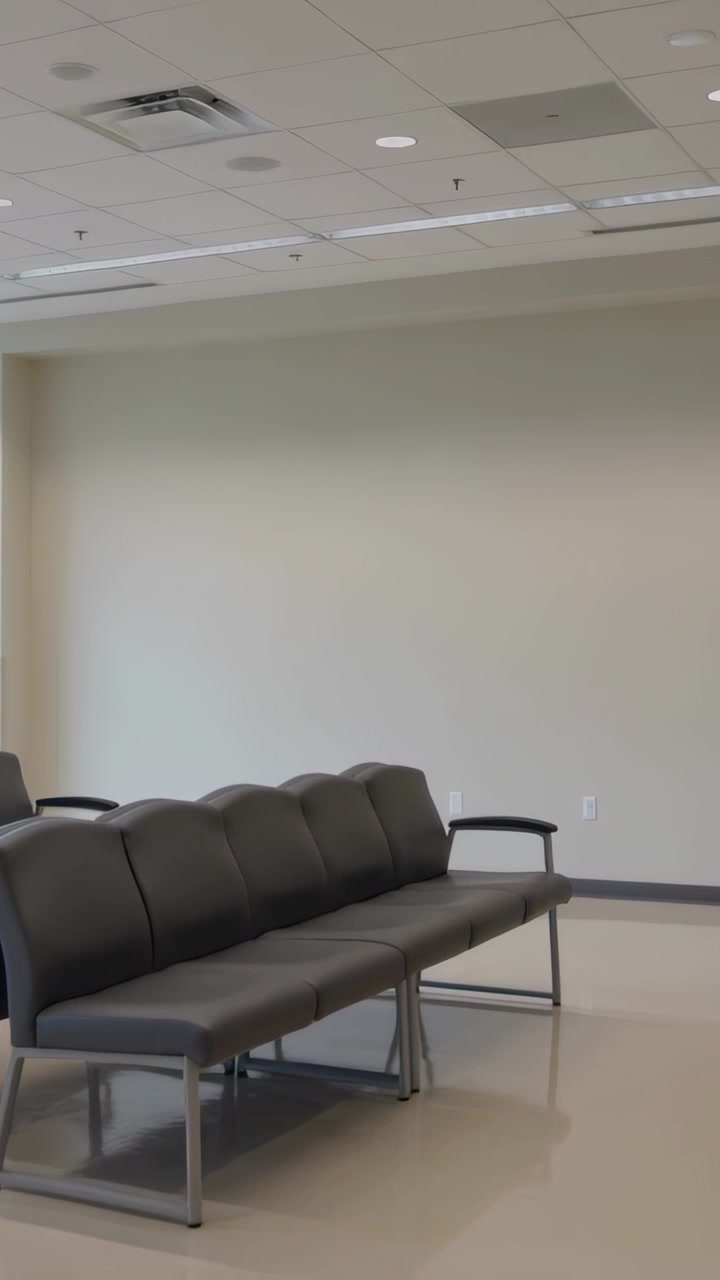 Video verticale: Panoramica della telecamera che rivela panchine grigie nella hall, mostrando una hall vuota e il luccichio del pavimento