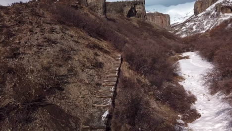 stairs leading up the side of a canyon towards rugged terrain