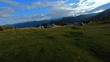 fpv footage was filmed in the slovenian mountain village in the alps with a drone flying fast over mountains filmed with a gopro with surrounding landscapes flying between and over small wooden cabins-6