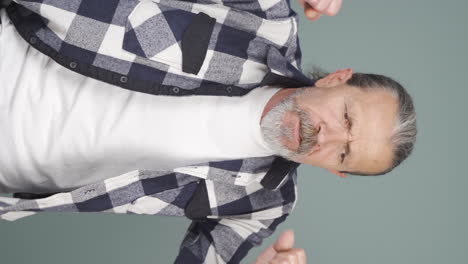 Vertical-video-of-Old-man-having-a-nervous-breakdown-in-front-of-the-camera.