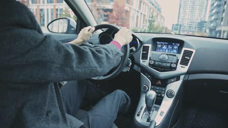 Man-Driving-Car-On-The-Road-With-Hands-On-Steering-Wheel---Backseat-View---medium-shot