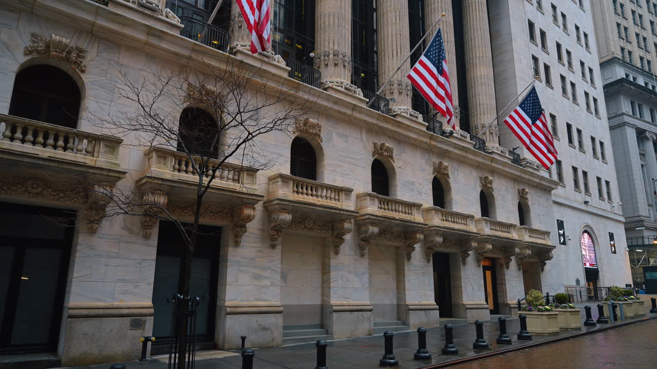 New York, USA, 8 febbraio 2026: Angolo di un edificio storico in pietra con balconi e bandiere nazionali. Vista laterale della facciata della New York Stock Exchange che mostra i dettagli architettonici.