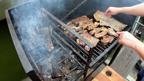 Cámara-Lenta-Del-Hombre-Blanco-En-Una-Parrilla-Negra-Cocinando-Carne-Asada-En-Un-Día-Soleado