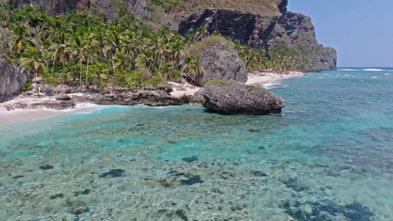 Turista fa il bagno nell'acqua cristallina su una pittoresca spiaggia tropicale, vista aerea