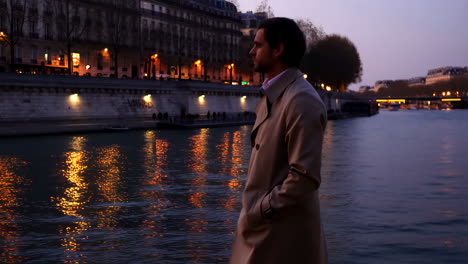 man in trench coat on seine river, paris