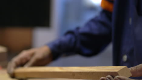 closeup of furniture maker spreading glue on wood, woodwork manufacturing industry