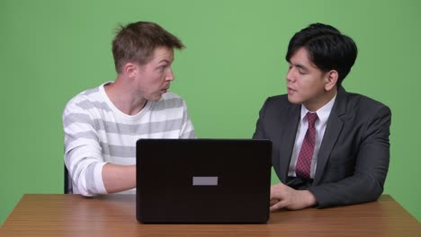 joven empresario asiático y joven empresario escandinavo trabajando juntos con una computadora portátil