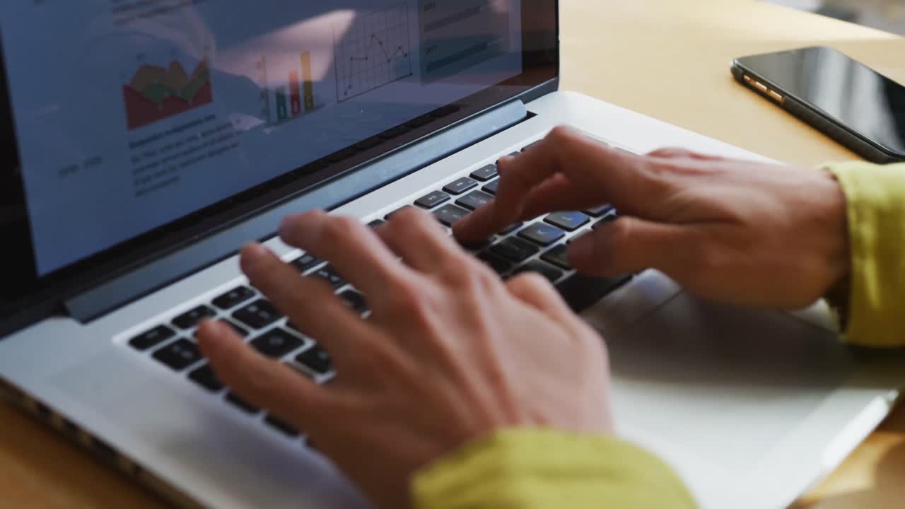 sección media de una mujer caucásica usando una computadora portátil y trabajando desde casa