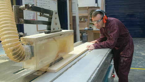 carpenter using circular saw in carpentry workshop