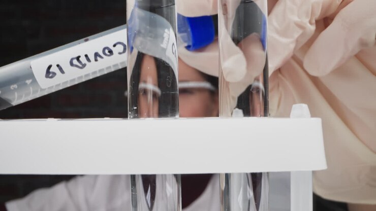 Lab worker looks at patient blood sample doing Covid test