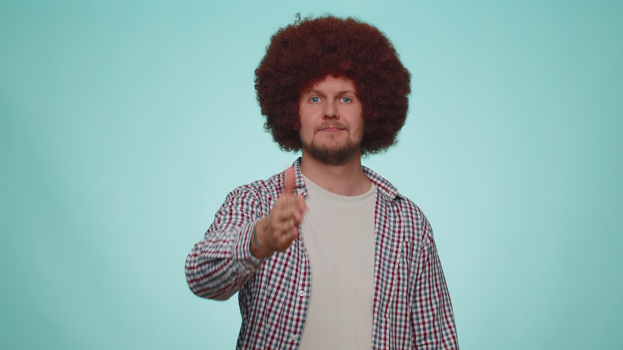 hombre amistoso extendiendo la mano a la cámara, ofreciendo un apretón de mano, saludando con una sonrisa amable, bienvenido