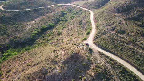 Forest-of-the-Crosses-Montserrat-Marganell-Spain-with-winding-dirt-road-through-hilly-terrain