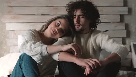 young romantic playful lovely couple sitting in bed wearing winter clothes