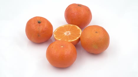 mandarinas frescas húmedas en una placa blanca girar el fondo. vista superior