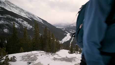 Una-Joven-Excursionista-Sonríe-Y-Sube-Una-Montaña-Nevada-En-El-Parque-Nacional-De-Banff