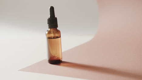 Close-up-of-glass-bottle-with-pump-and-copy-space-on-pink-background