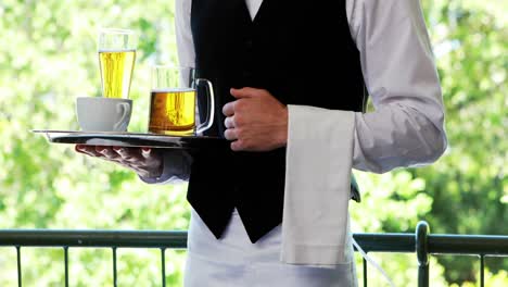 male waiter holding tray with coffee cup and beer mug in restaurant 4k