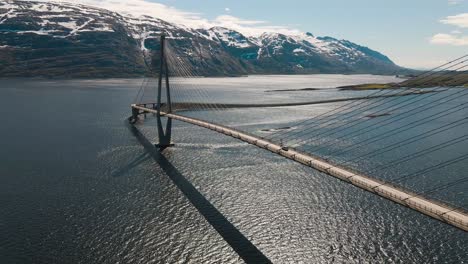 4K-Drohnenweitwinkelaufnahme-Mit-Parallaxenbewegung-Des-Ruhigen-Fjords-Und-Der-Majestätischen-Brücke-In-Helgeland,-Einer-Berühmten-Touristenattraktion-Auf-Der-Norwegischen-Touristenroute-Helgelandskysten,-Helgelandsbrua,-Norwegen