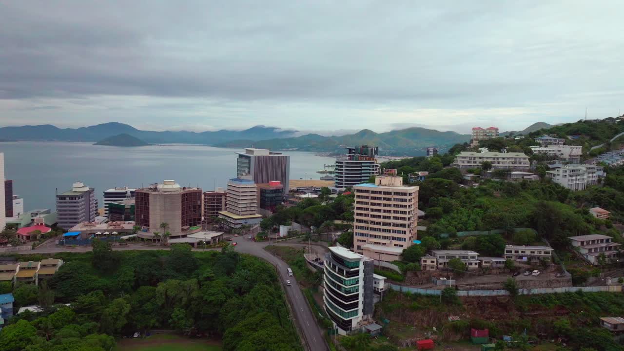 Morning cloudy foggy sunrise Port Moresby Harbour Crown Hotel Plaza Hilton Ela Beach Papua New Guinea aerial drone PNG Walter Bay rainy Coral sea coastline capital city mountains forwards motion