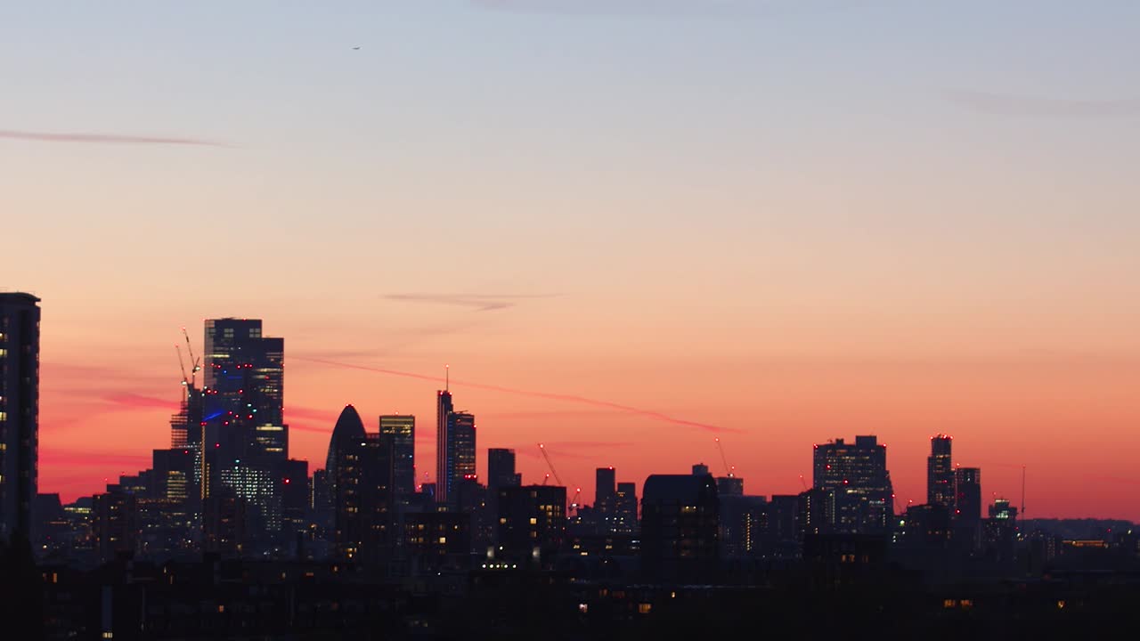 City of London skyline silhouetted at sunset. Static tripod shot