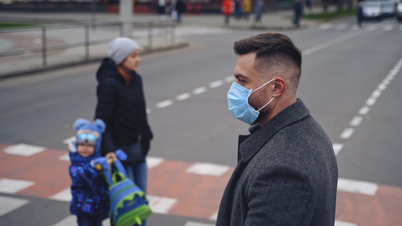 Street life during coronavirus pandemic. Man wearing mask crossing street during pandemic