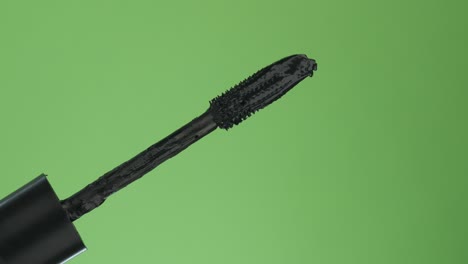 diagonal rotation brush mascara. isolated on green.