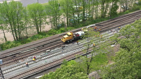 an aerial view over men repairing train tracks on a sunny day